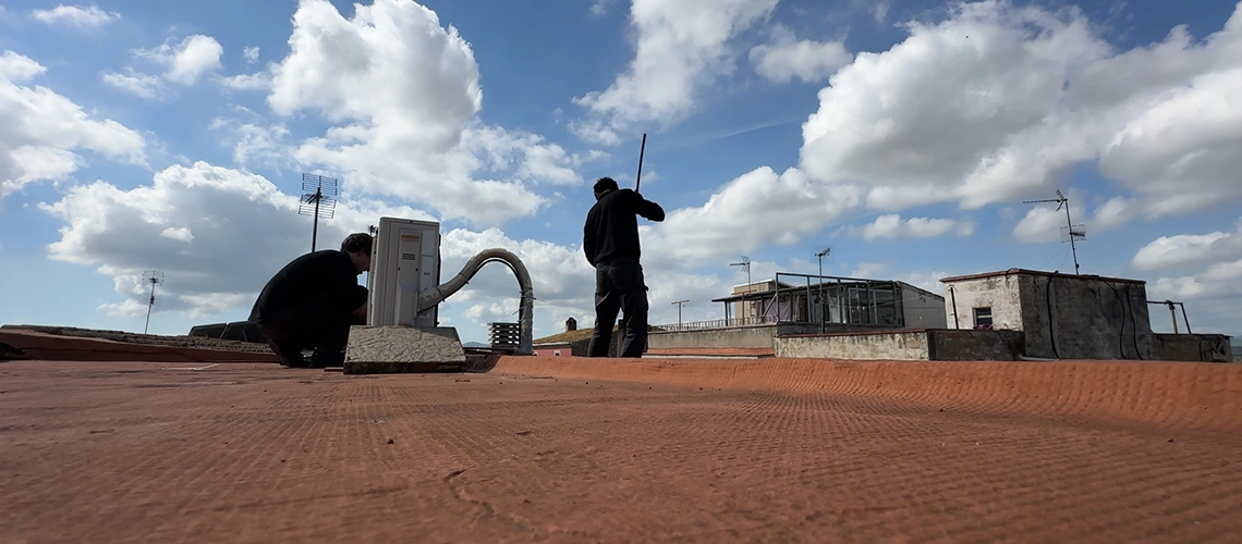 Técnico de Lasua Deshollinados realizando deshollinación de chimenea desde el tejado con equipos de seguridad y limpieza profesional